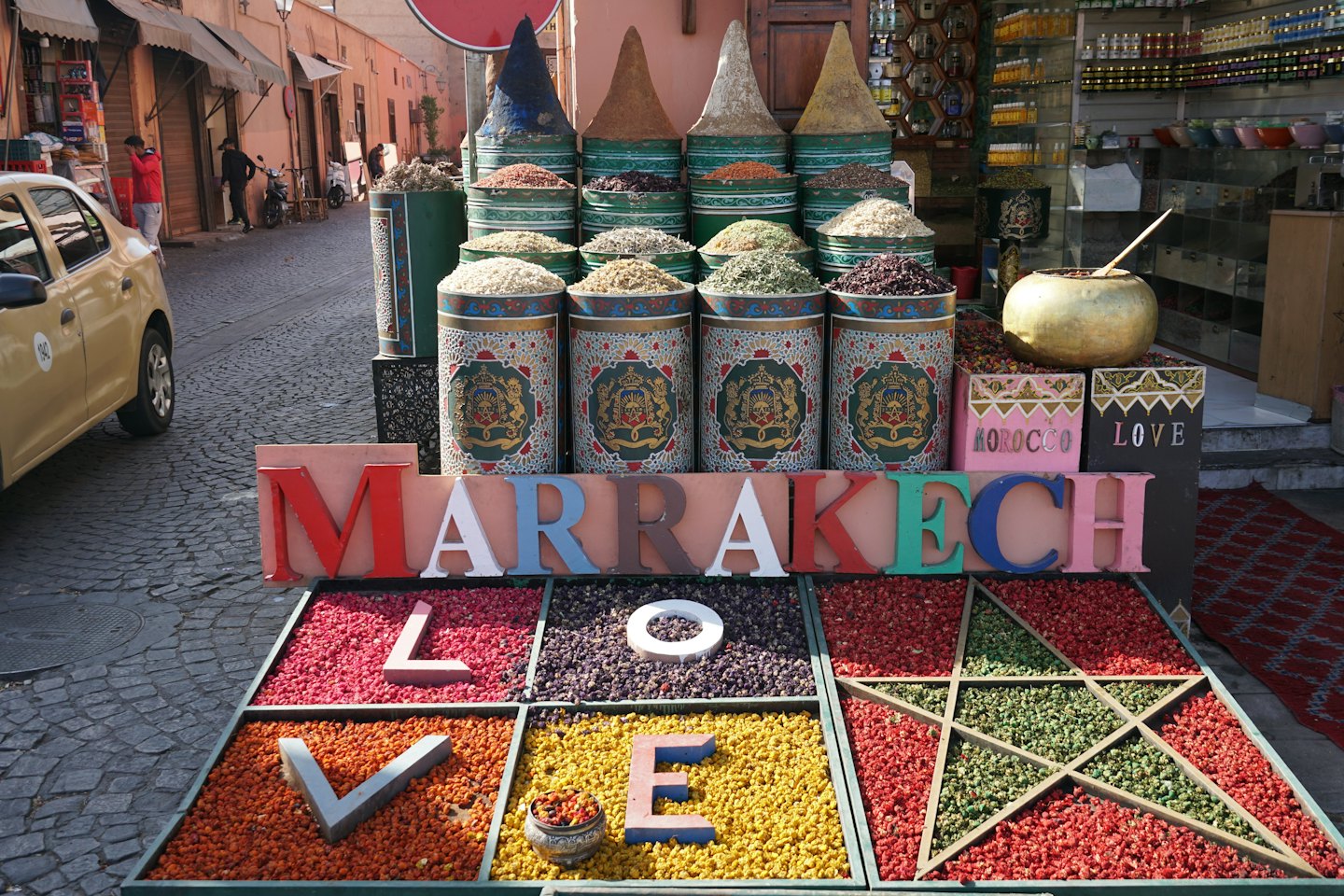 Bulk spices and herbs displayed at a bustling market stall.